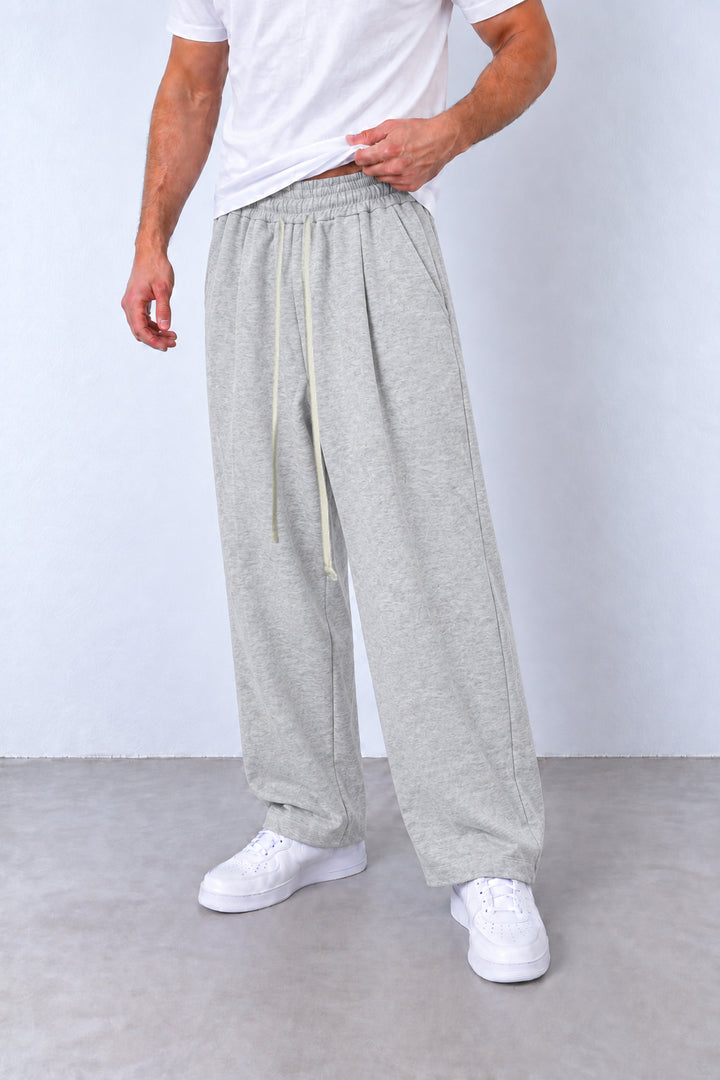 Pantaloni gri-melanj LEO26 pe model, vedere din trei sferturi cu talie elastică, șnur lung și tivuri simple.