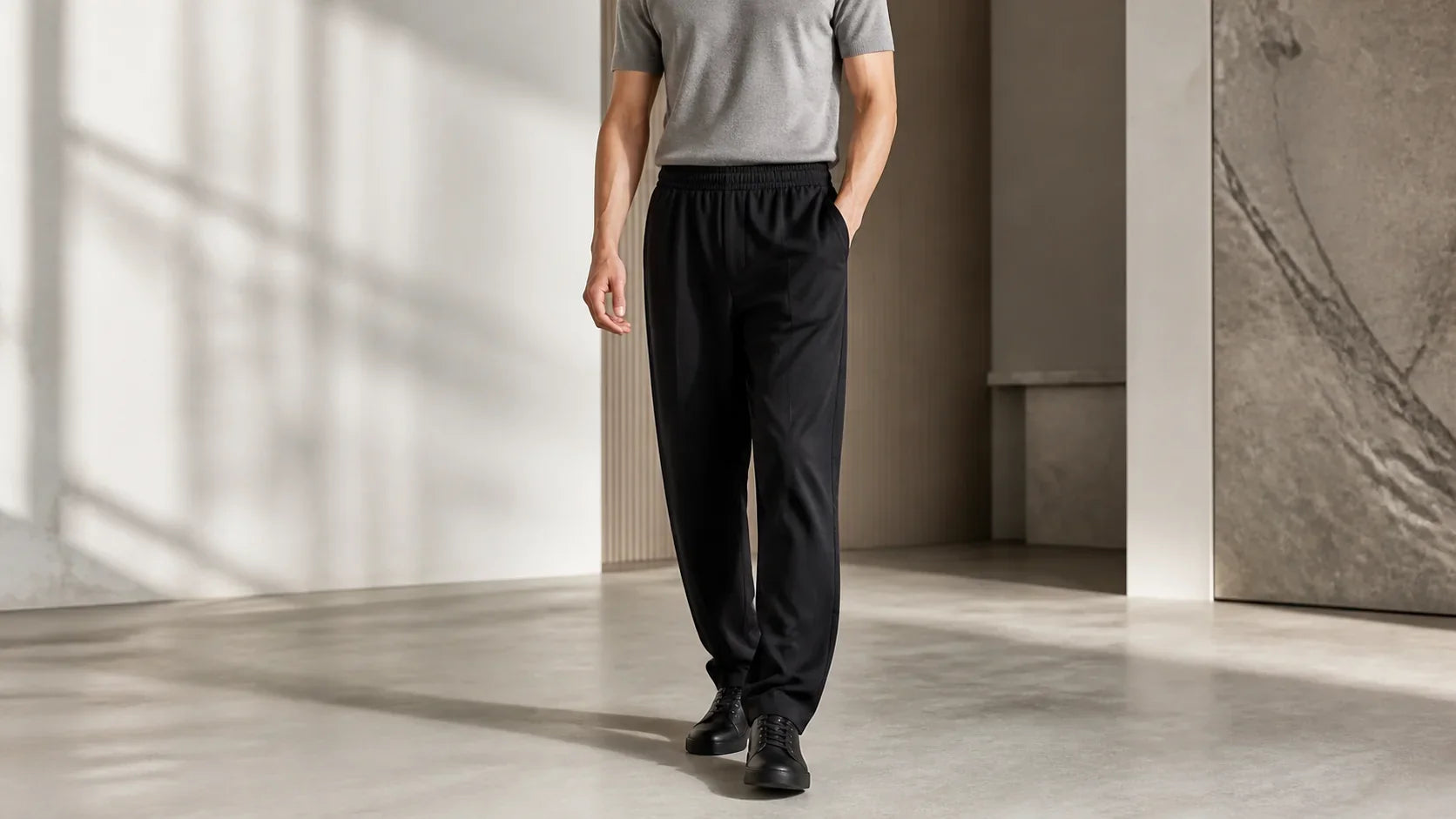 Bărbat purtând pantaloni negri din modal cu o cădere fluidă