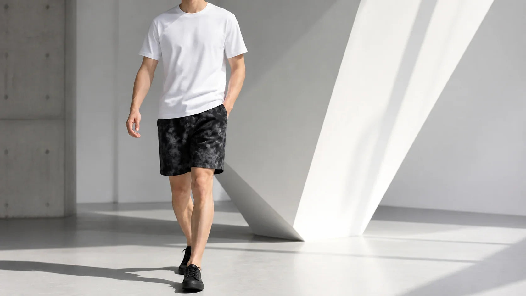 Bărbat purtând pantaloni scurți tie-dye negri cu tricou alb