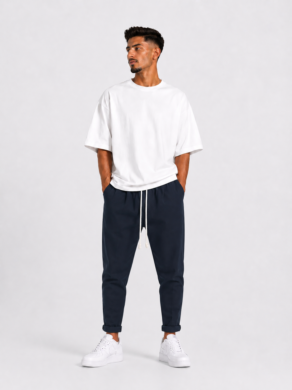Bărbat purtând pantaloni bleumarin slim cu șiret lung într-un outfit streetwear modern și relaxat.