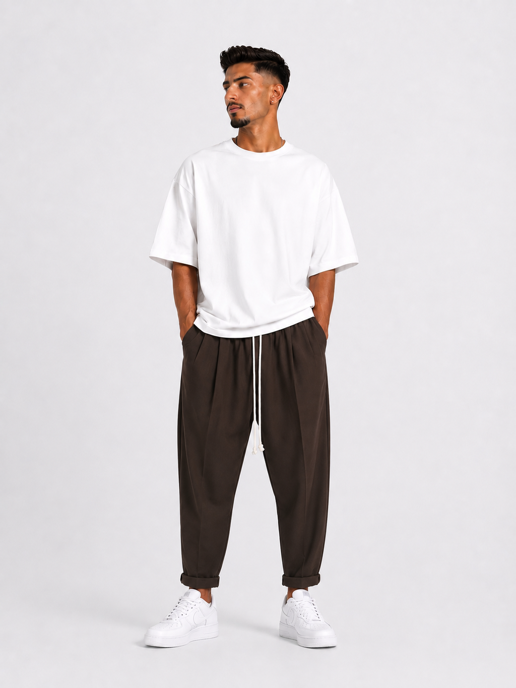 Bărbat purtând pantaloni maro slim cu șiret lung într-un outfit streetwear modern și relaxat.