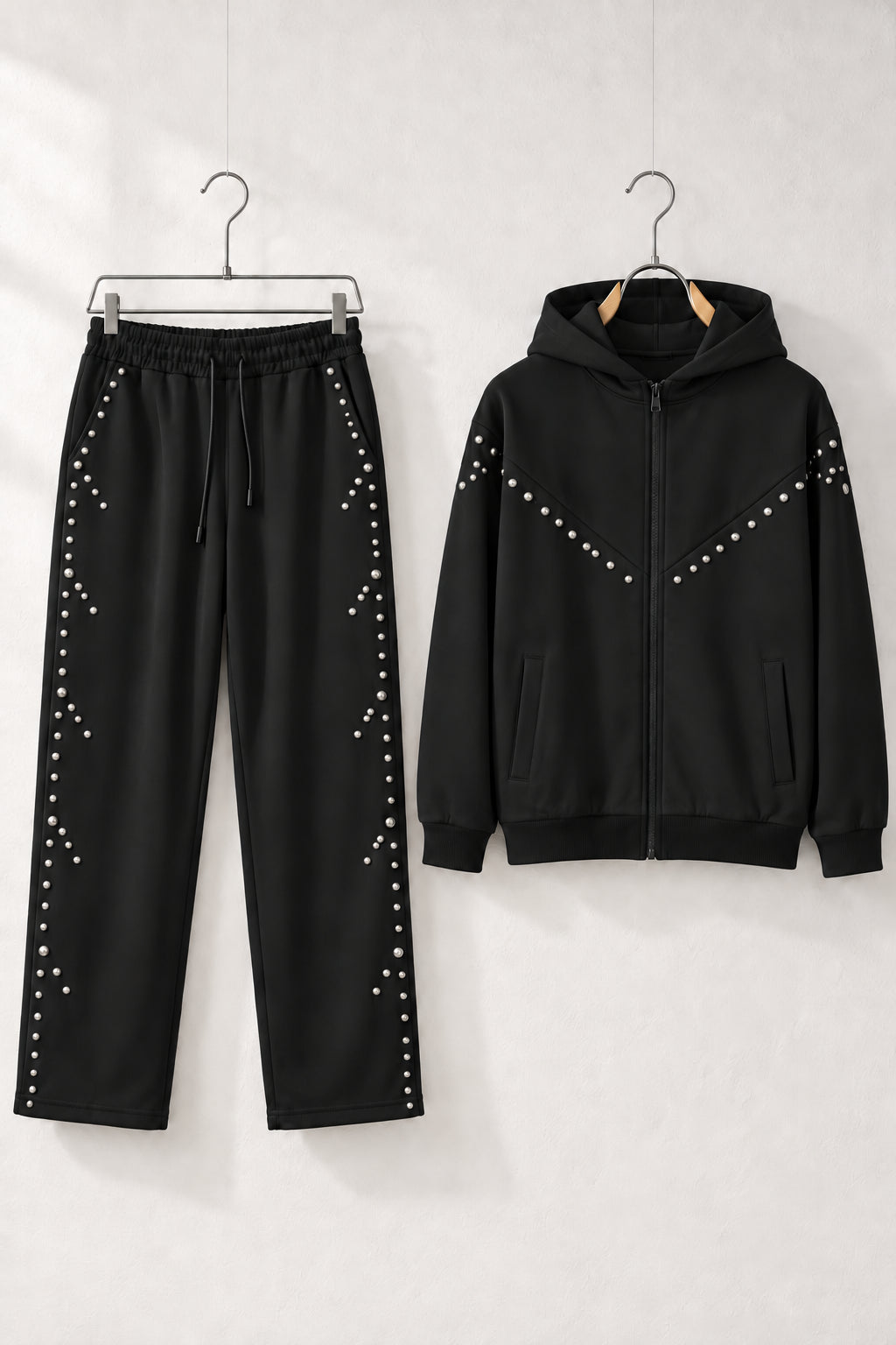 Compleu negru pentru bărbați cu hanorac cu fermoar și pantaloni drepți, decorați cu capse argintii, pe umerașe