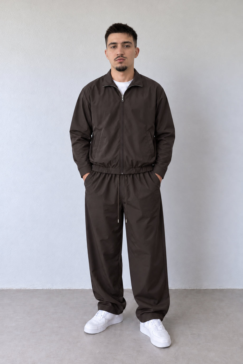 Compleu bărbătesc maro L815567 cu jachetă cu fermoar și pantaloni, vedere frontală pe model