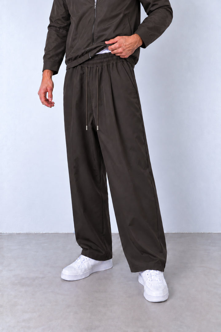 Pantaloni maro din compleul L815567, vedere din trei sferturi cu șnururi tonale și terminații argintii