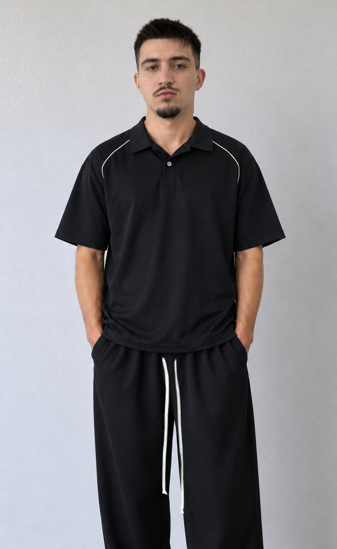 Detaliu polo negru FMT66 cu paspoal deschis pe umeri și pantaloni asortați