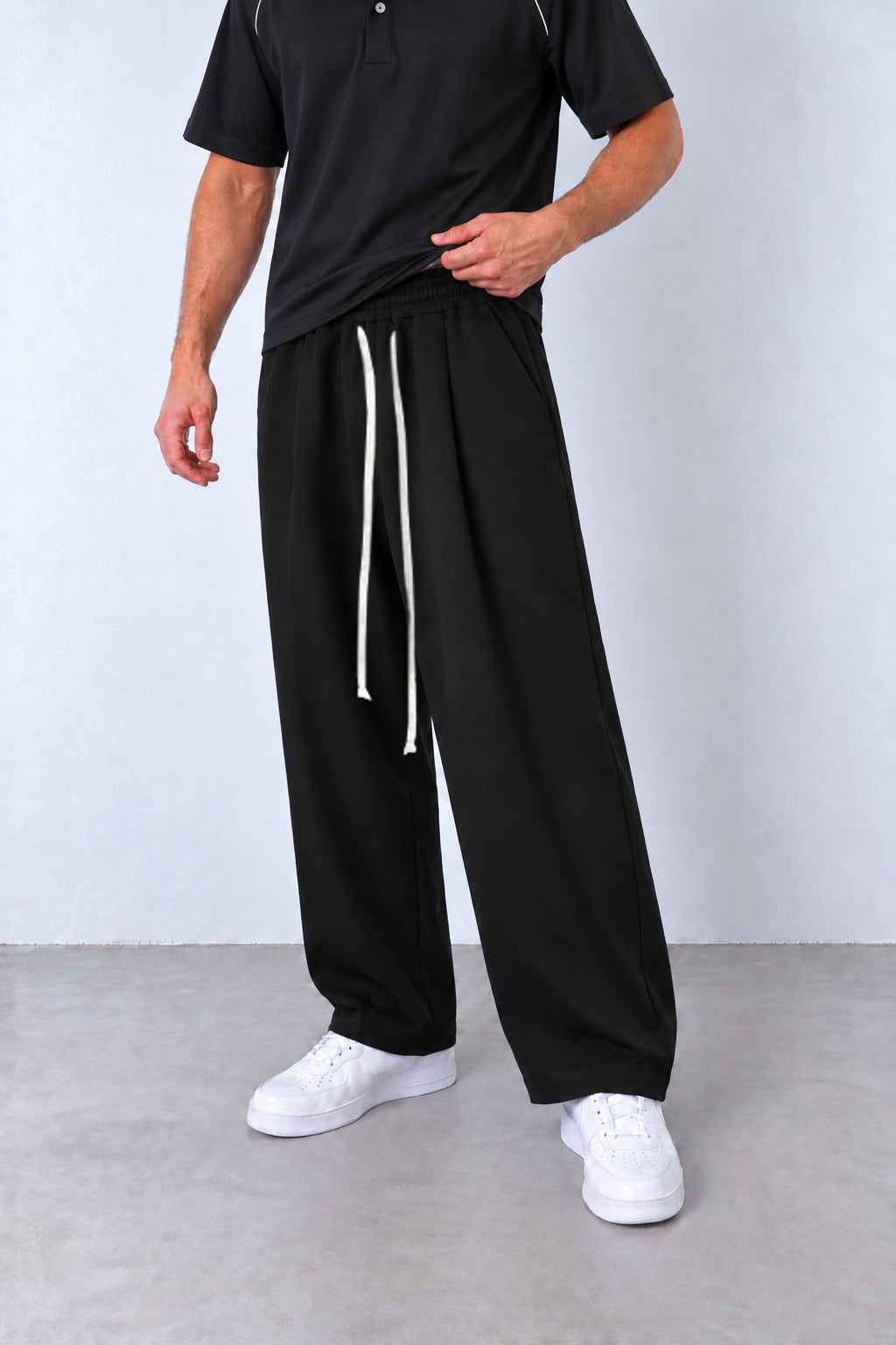 Pantaloni negri FMT67 din compleul cu polo, vedere din trei sferturi și șnururi deschise