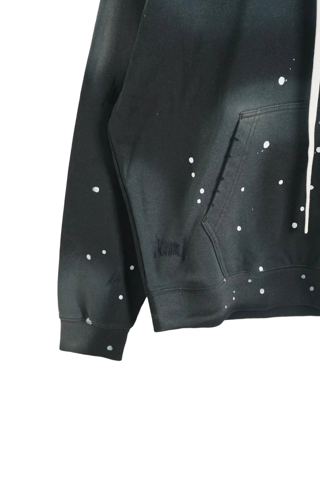 Detaliu textură din bumbac cu model artistic tip paint splatter pe un hanorac de bărbați.