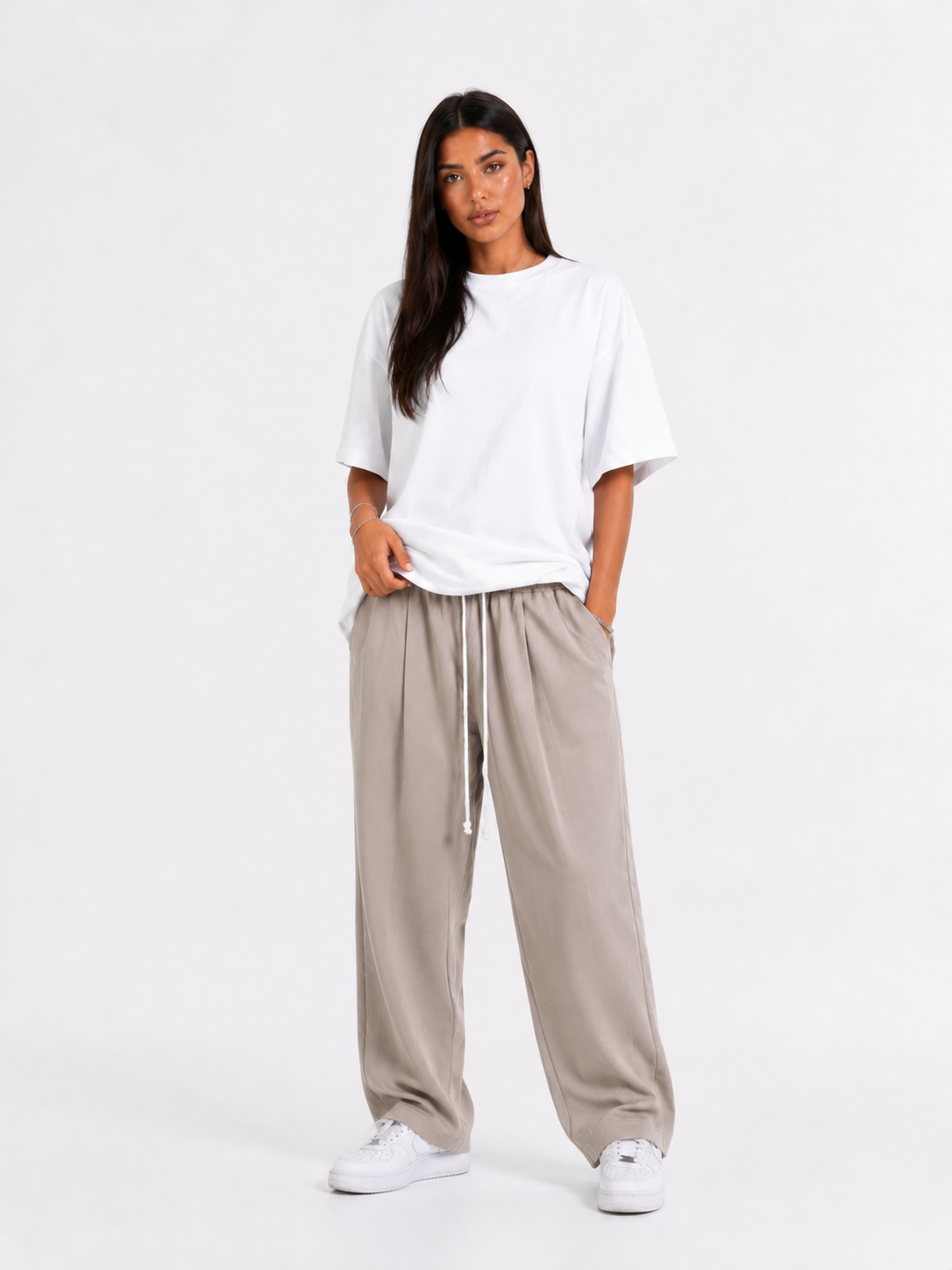 Femeie purtând pantaloni bej oversized cu șiret lung într-un look casual modern și confortabil