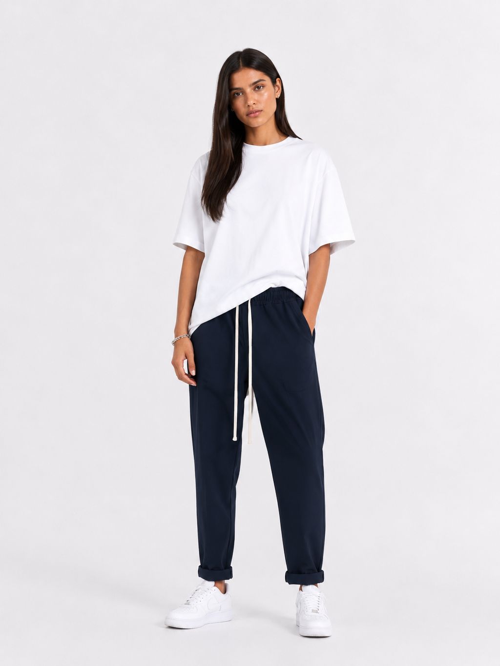 Femeie purtând pantaloni bleumarin cu șiret lung într-un look casual modern și confortabil.