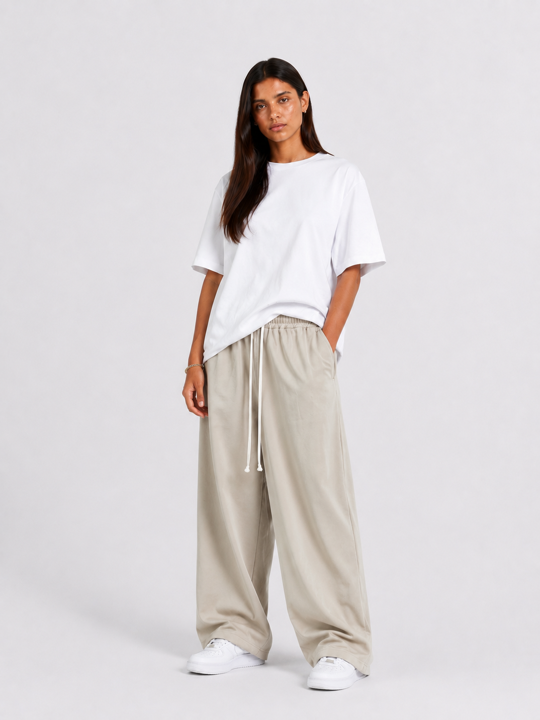 Femeie purtând pantaloni crem cu șiret lung într-un look casual modern și relaxat.