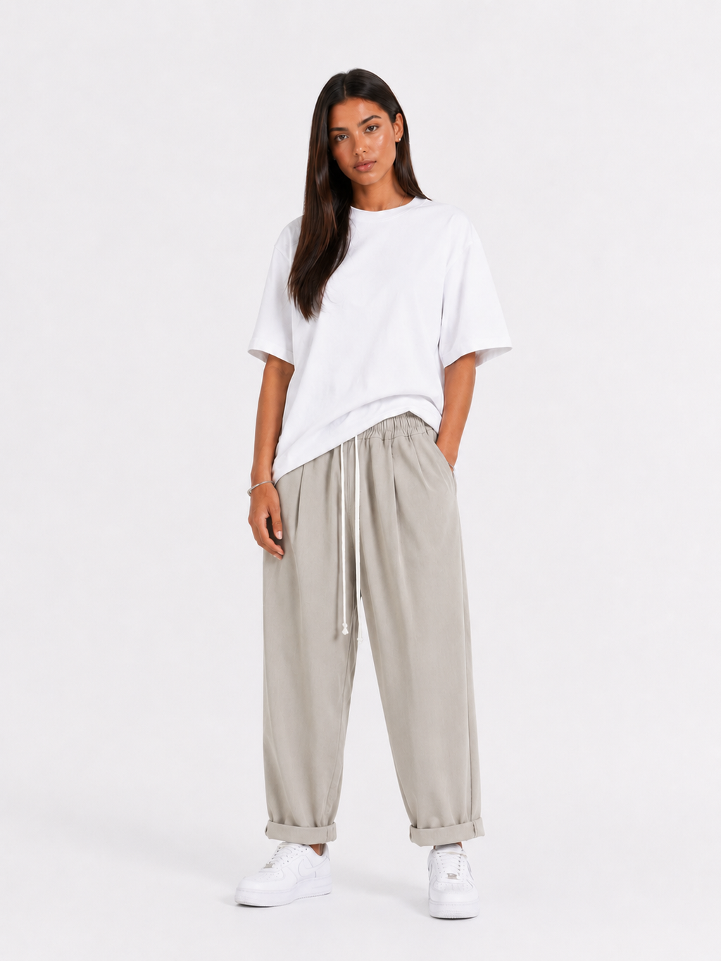 Femeie purtând pantaloni crem cu șiret lung într-un look casual modern și confortabil.