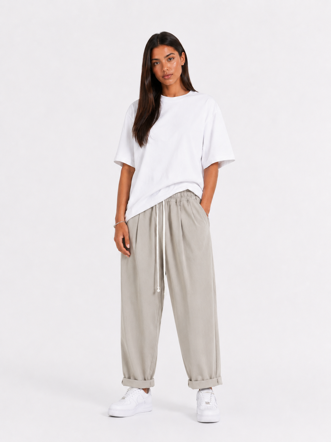 Femeie purtând pantaloni crem cu șiret lung într-un look casual modern și confortabil.