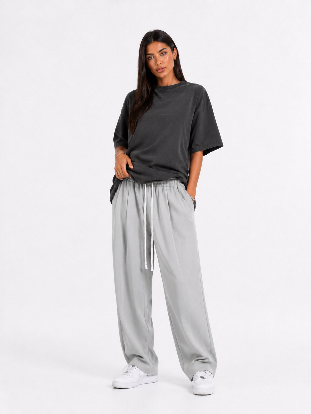 Model feminin cu pantaloni gri cu șnur lung și croială lejeră pentru outfituri trendy.