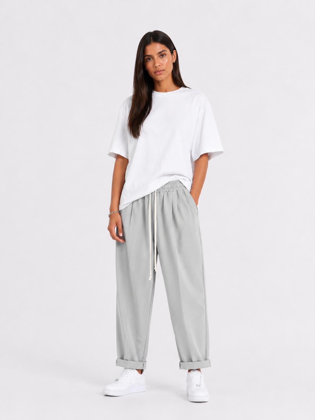 Femeie purtând pantaloni gri cu șiret lung într-un look casual modern și confortabil.