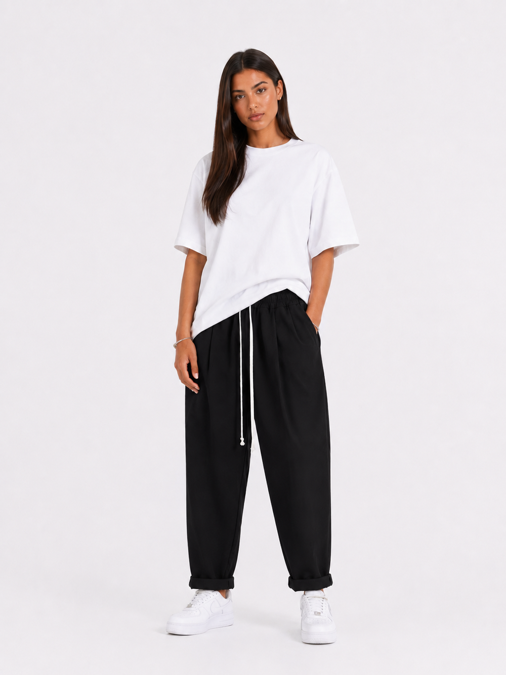 Femeie purtând pantaloni negri cu șiret lung într-un look casual modern și confortabil