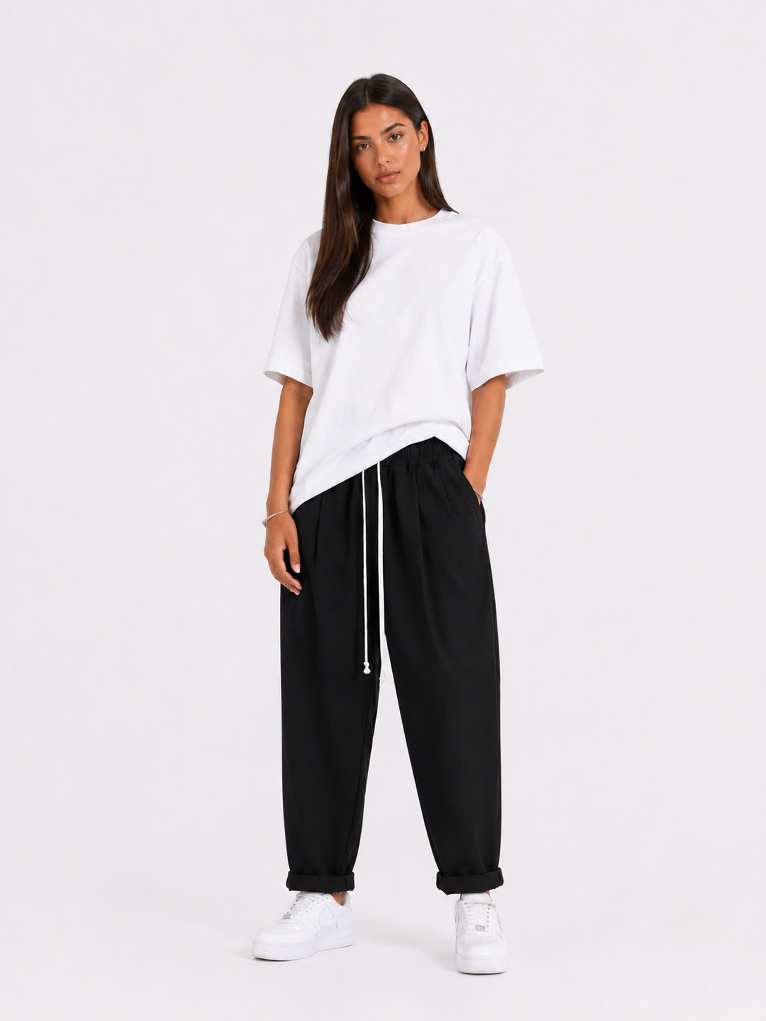 Femeie purtând pantaloni negri cu șiret lung într-un look casual modern și confortabil
