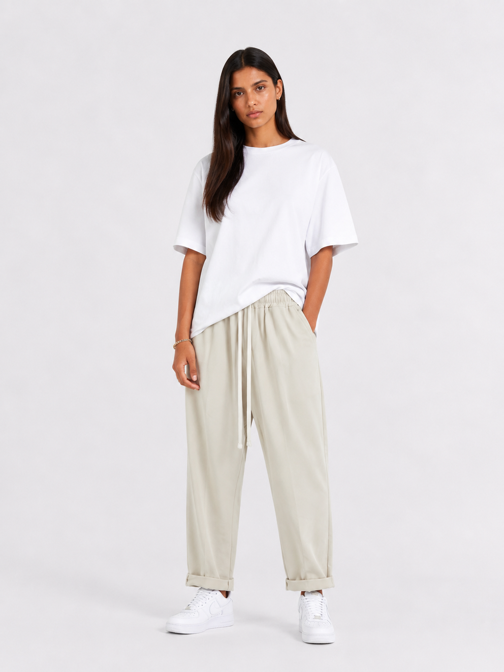 Femeie purtând pantaloni crem cu șiret lung într-un look casual modern și relaxat.
