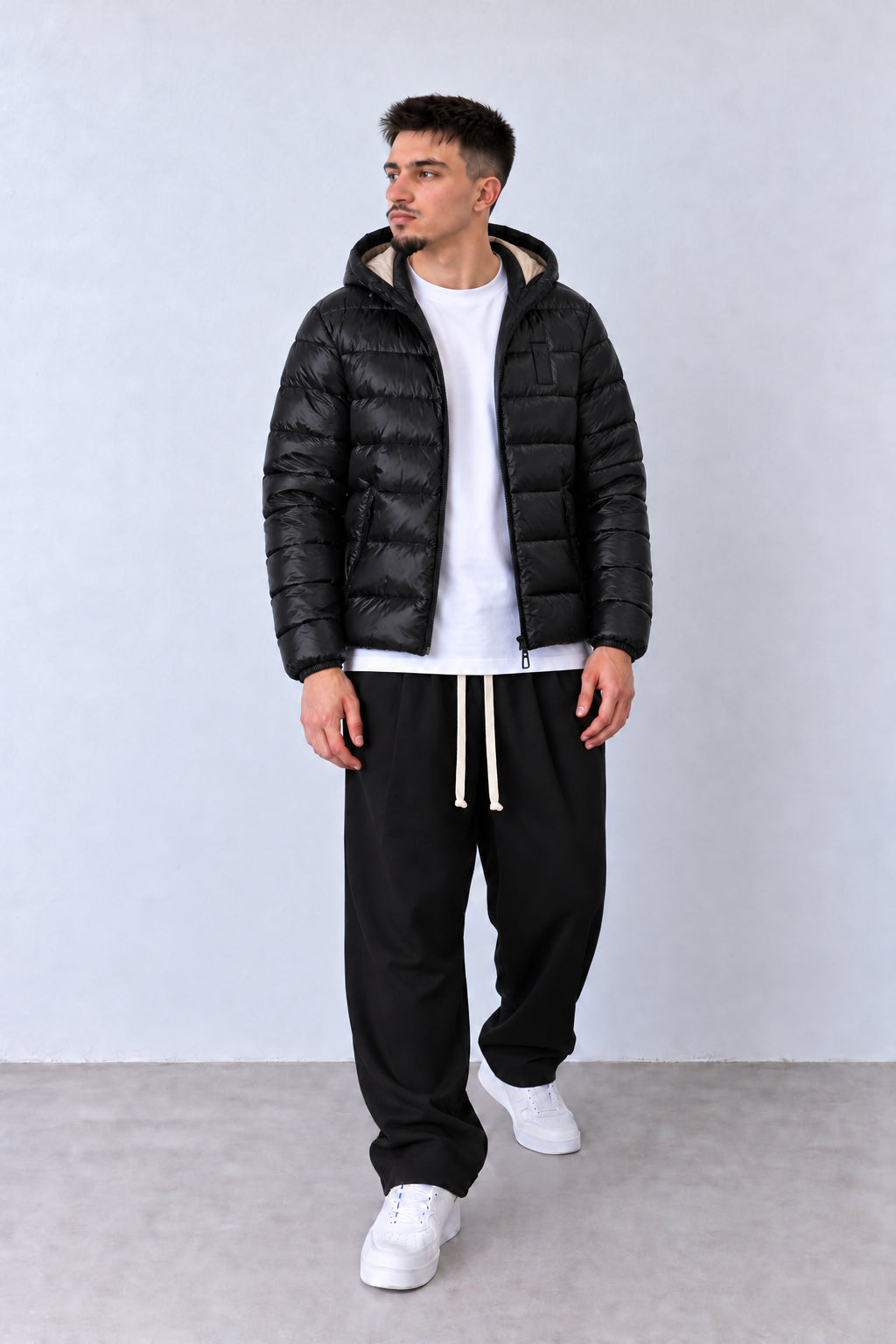 Geacă Puffer Bărbați Neagră cu Glugă, vedere pe model cu poziție alternativă a brațelor și picioarelor.