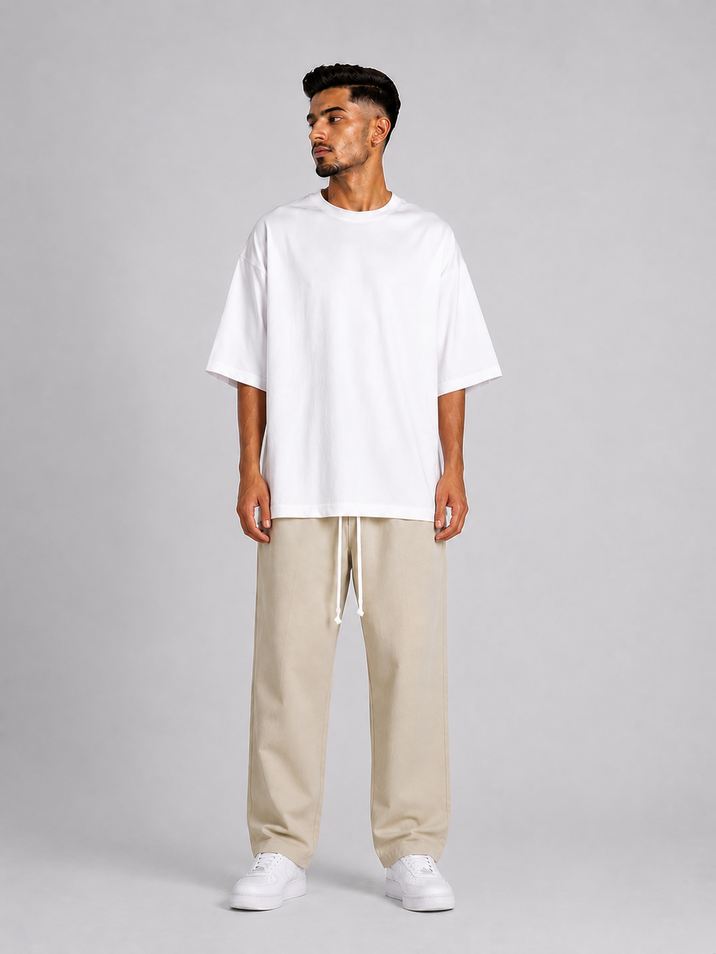 Outfit bărbătesc streetwear cu pantaloni crem și siret lung pentru stil contemporan.