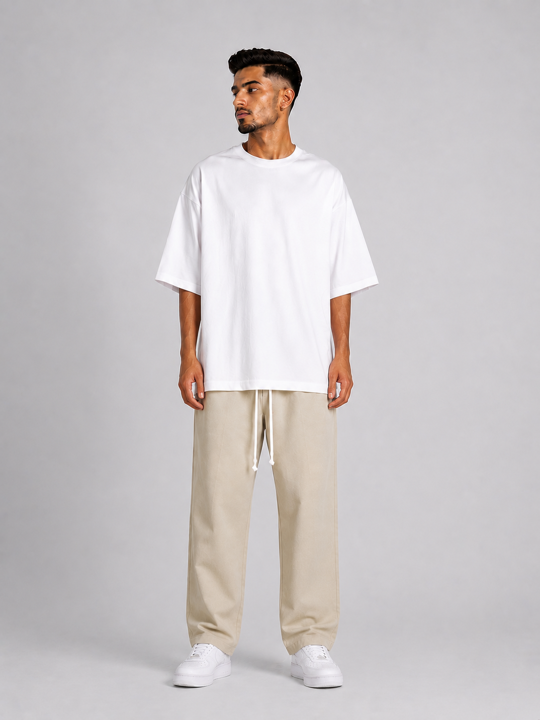 Outfit bărbătesc streetwear cu pantaloni crem și siret lung pentru stil contemporan.