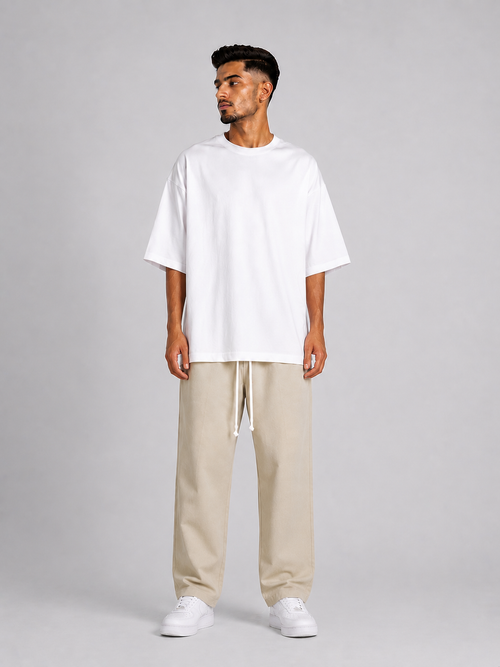 Outfit bărbătesc streetwear cu pantaloni crem și siret lung pentru stil contemporan.