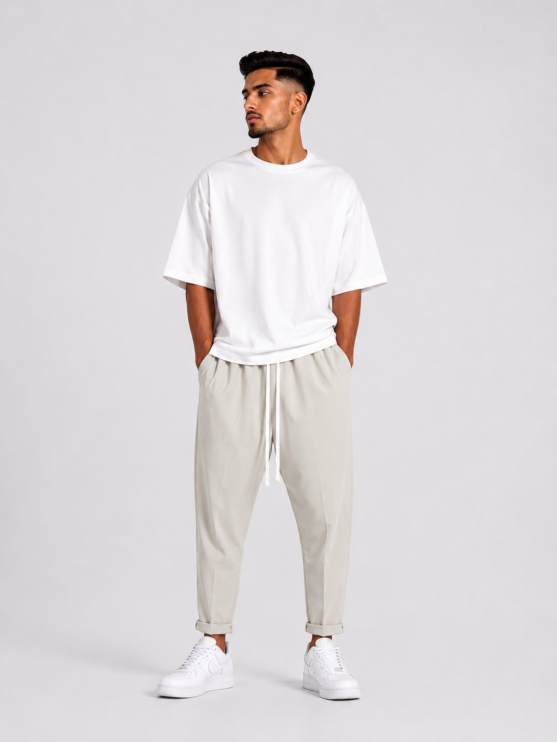 Bărbat purtând pantaloni crem slim cu șiret lung într-un outfit modern și confortabil.