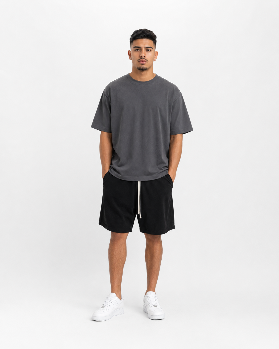 Model masculin purtând tricou oversized charcoal și pantaloni scurți streetwear negri