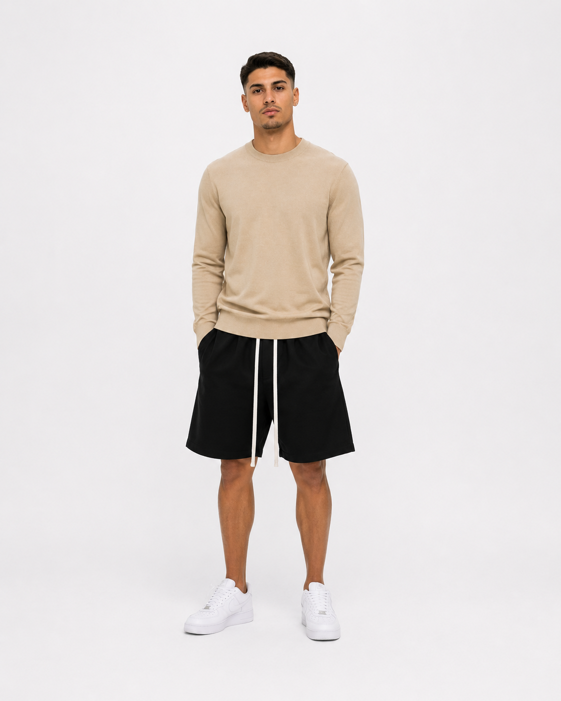 Model masculin purtând bluză bej slim fit premium și pantaloni scurți negri minimalist