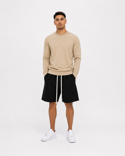 Model masculin purtând bluză bej slim fit premium și pantaloni scurți negri minimalist