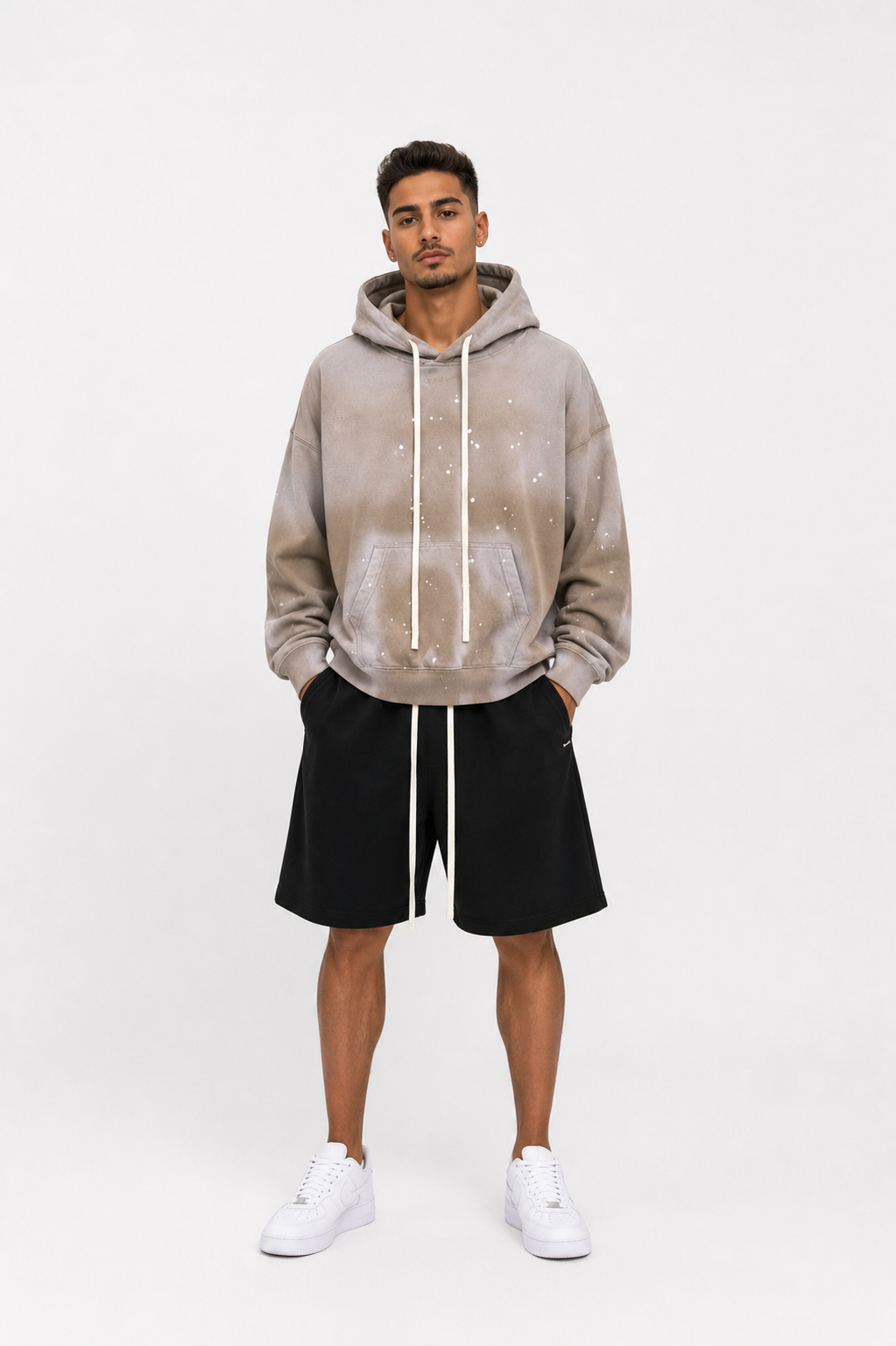 Model masculin purtând hanorac oversized bej cu șnur lung și pantaloni scurți streetwear premium