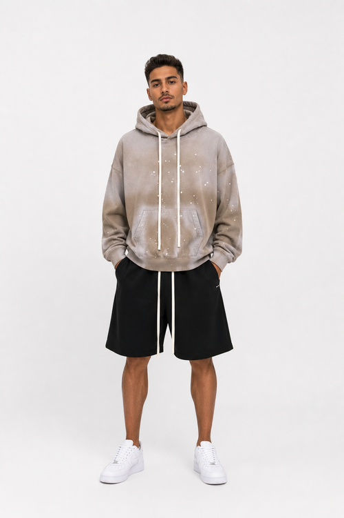 Model masculin purtând hanorac oversized bej cu șnur lung și pantaloni scurți streetwear premium