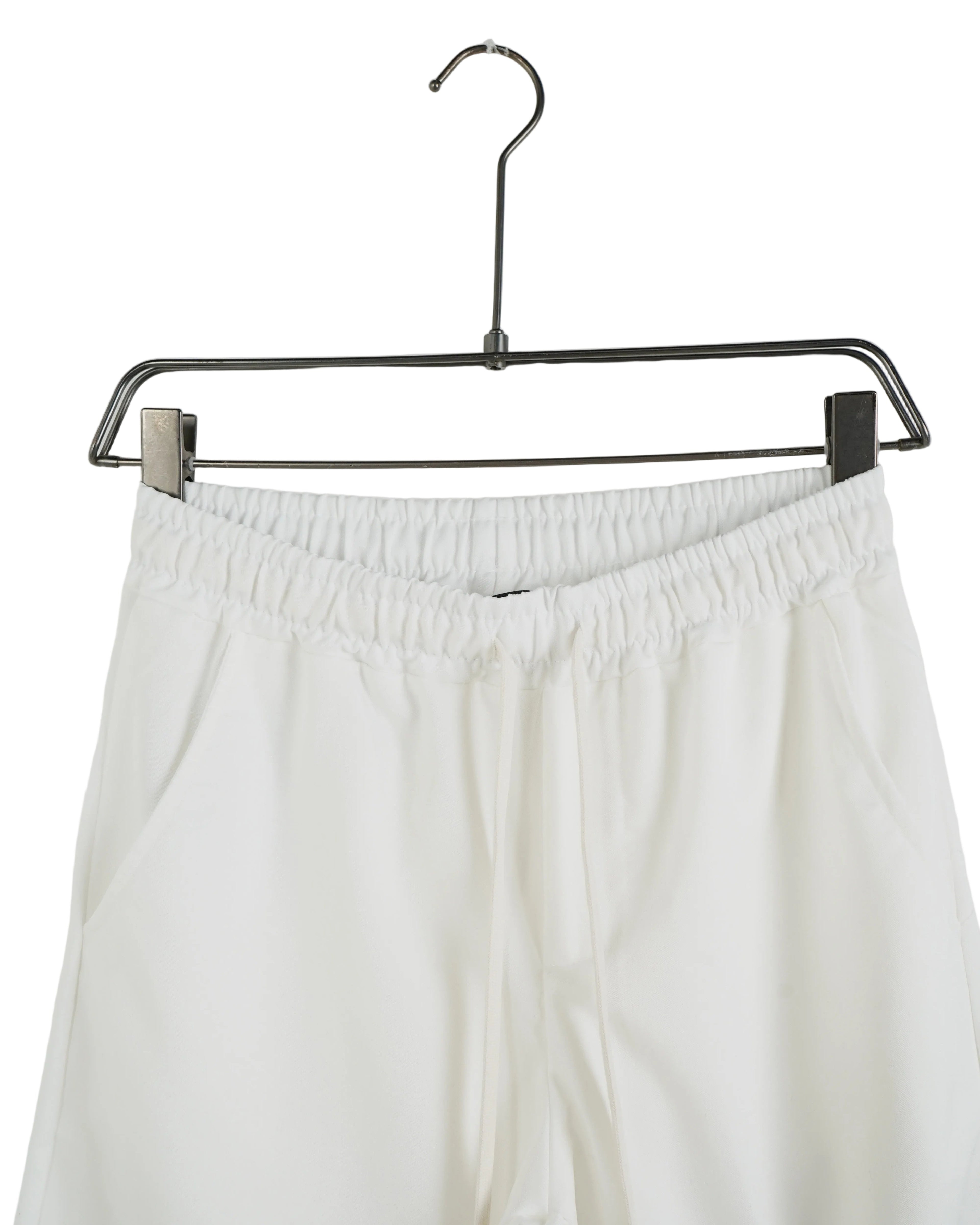 Detaliu talie elastică și șnur alb la pantaloni casual croială conică