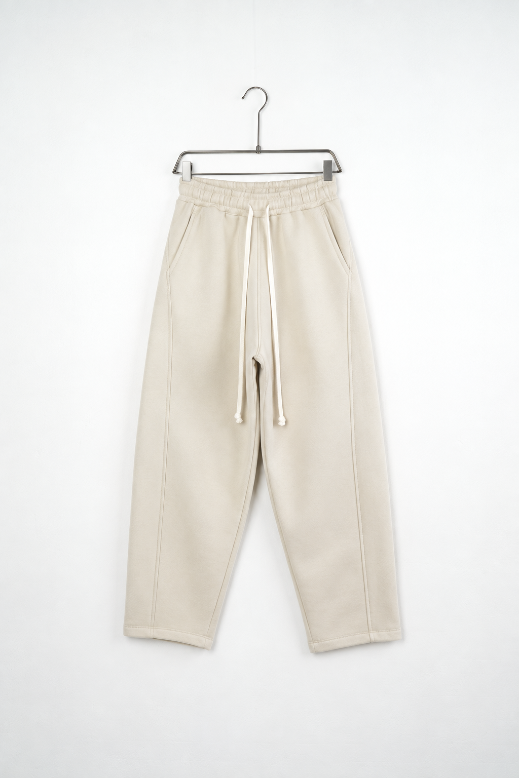 Pantaloni Baggy Felpați Bărbați Bej, vedere frontală pe umeraș, fundal deschis