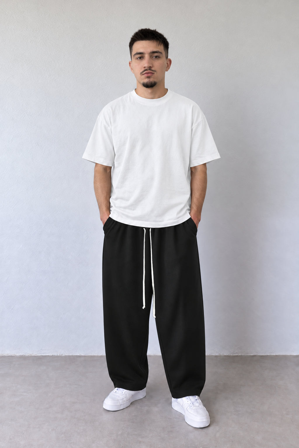 Pantaloni baggy negri 202501-INV pentru bărbați, vedere frontală pe model cu tricou alb și șnur lung