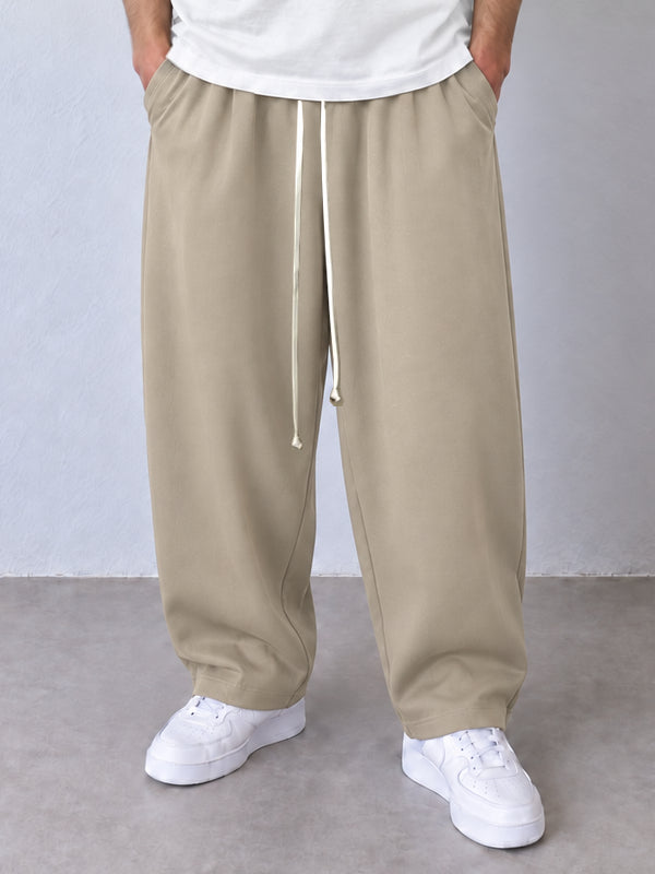 Detaliu pantaloni bej, talie cu șnur textil lung și croială baggy