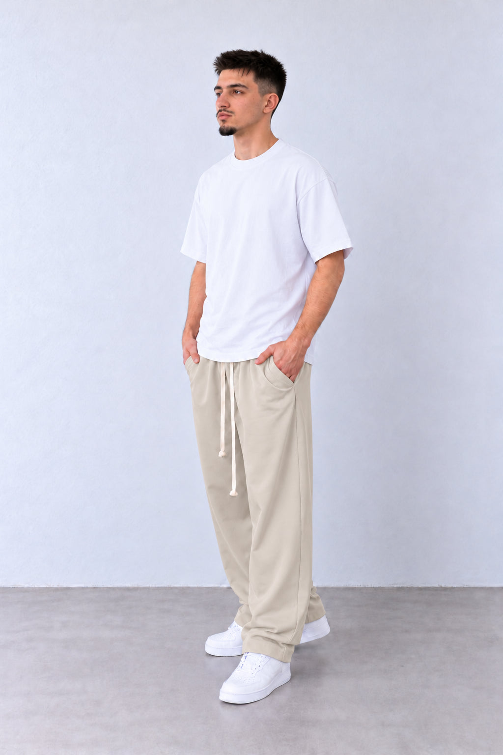 Pantaloni Bărbați Bej Deschis Largi cu Șnur Lung, vedere integrală pe model cu capul ușor întors sau înclinat.