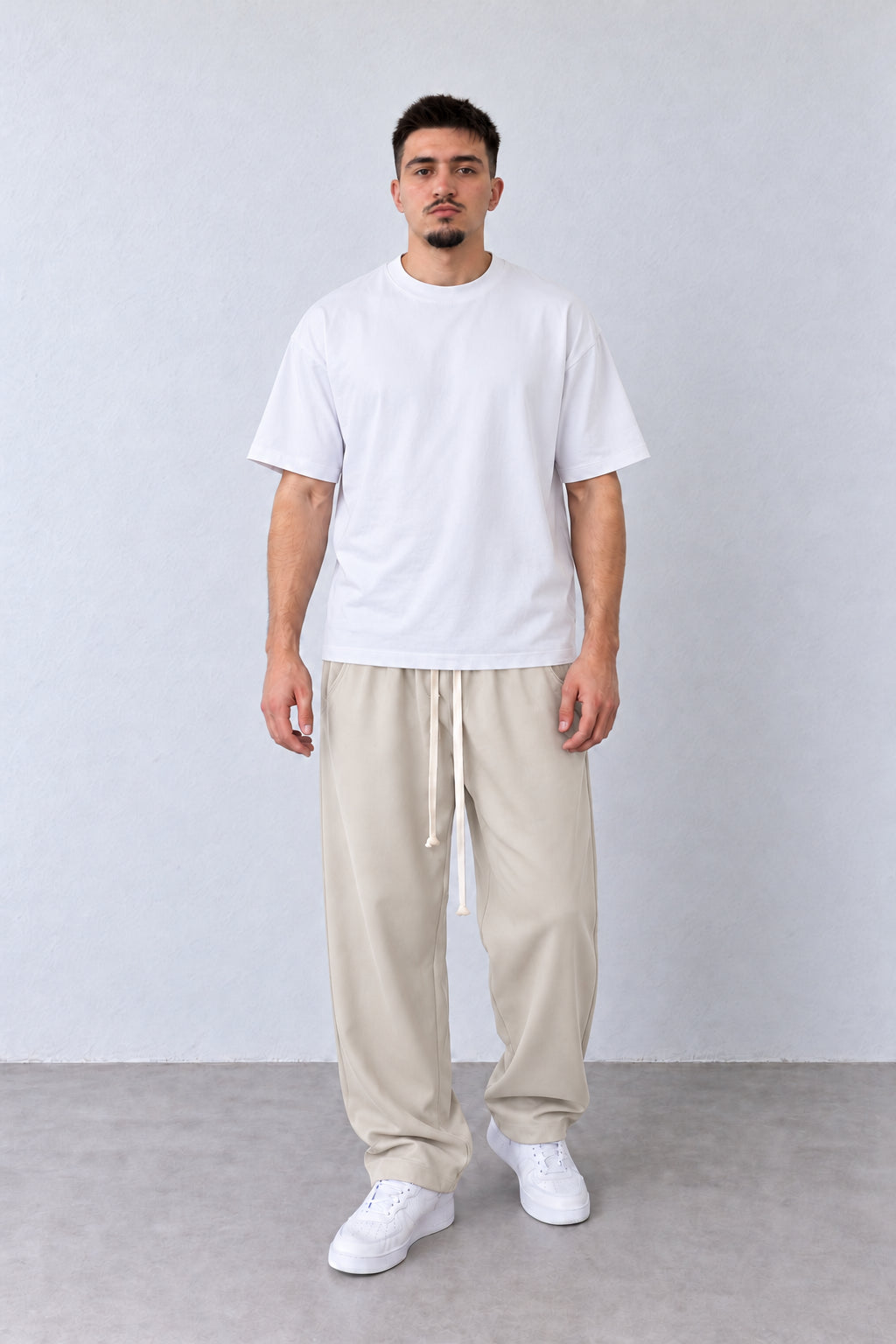 Pantaloni Bărbați Bej Deschis Largi cu Șnur Lung, vedere pe model cu poziție alternativă a brațelor și picioarelor.