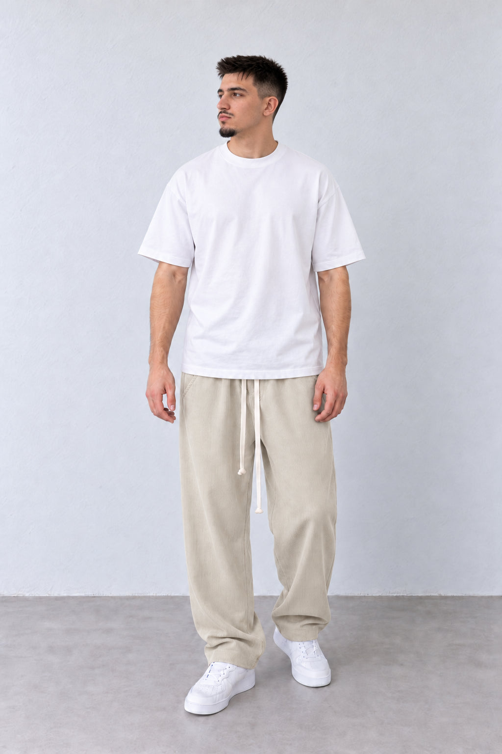 Pantaloni Bărbați Bej Deschis Raiați Largi cu Șnur Lung, vedere pe model cu poziție alternativă a brațelor și picioarelor.
