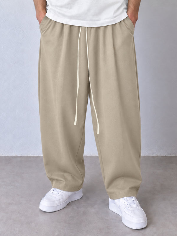 Pantaloni largi bej, vedere frontală apropiată cu șnur alb lung și tivuri simple.
