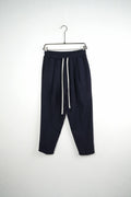 Pantaloni bleumarin carrot fit pentru bărbați, cu talie elastică și șnururi albe, vedere frontală integrală pe umeraș