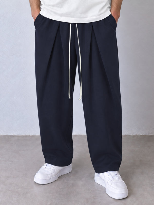 Pantaloni bleumarin, cadru frontal apropiat cu pense, șnur lung și tivuri simple.