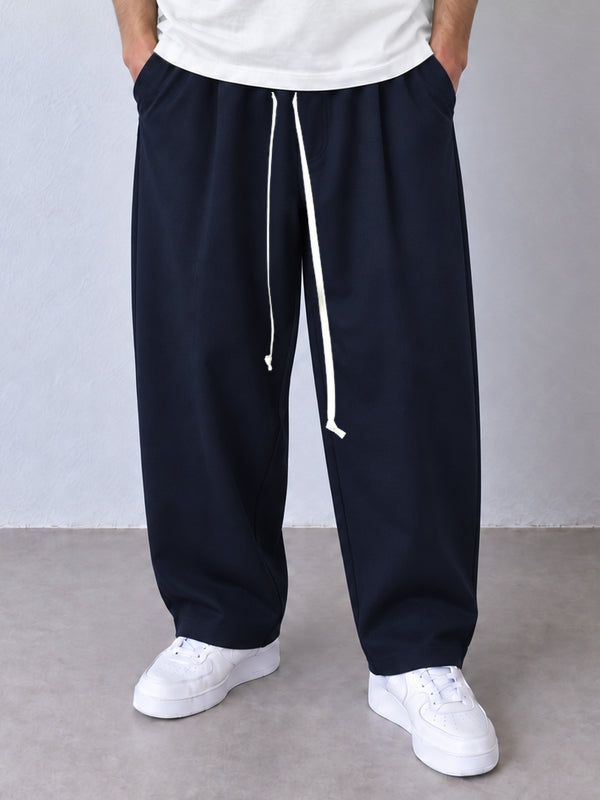 Pantaloni bleumarin, cadru frontal apropiat cu șnur lung și terminații simple la glezne.