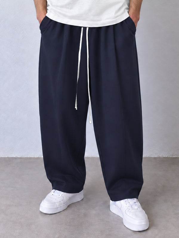 Pantaloni largi bleumarin, vedere frontală apropiată cu șnur alb lung și tivuri simple.