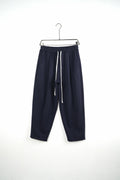 Pantaloni bleumarin baggy pentru bărbați, cu talie elastică și șnururi albe, vedere frontală integrală pe umeraș