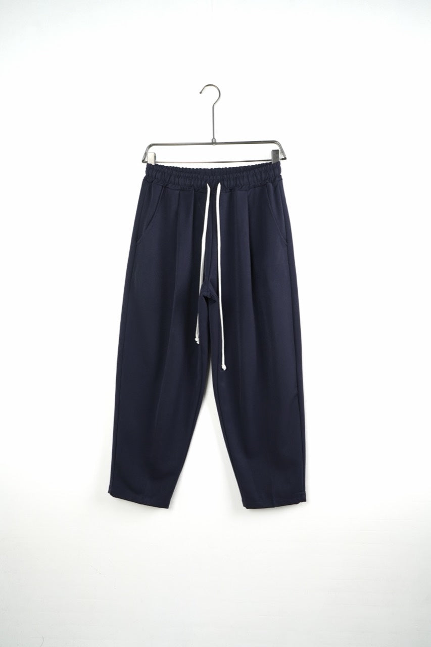 Pantaloni bleumarin baggy pentru bărbați, cu talie elastică și șnururi albe, vedere frontală integrală pe umeraș