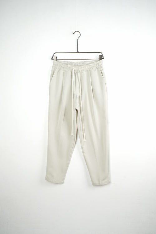 Pantaloni crem carrot fit pentru bărbați, cu talie elastică și șnururi albe, vedere frontală integrală pe umeraș