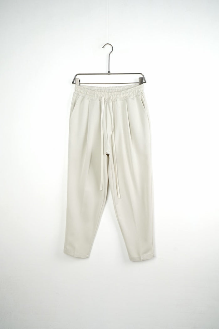 Pantaloni crem carrot fit pentru bărbați, cu talie elastică și șnururi albe, vedere frontală integrală pe umeraș