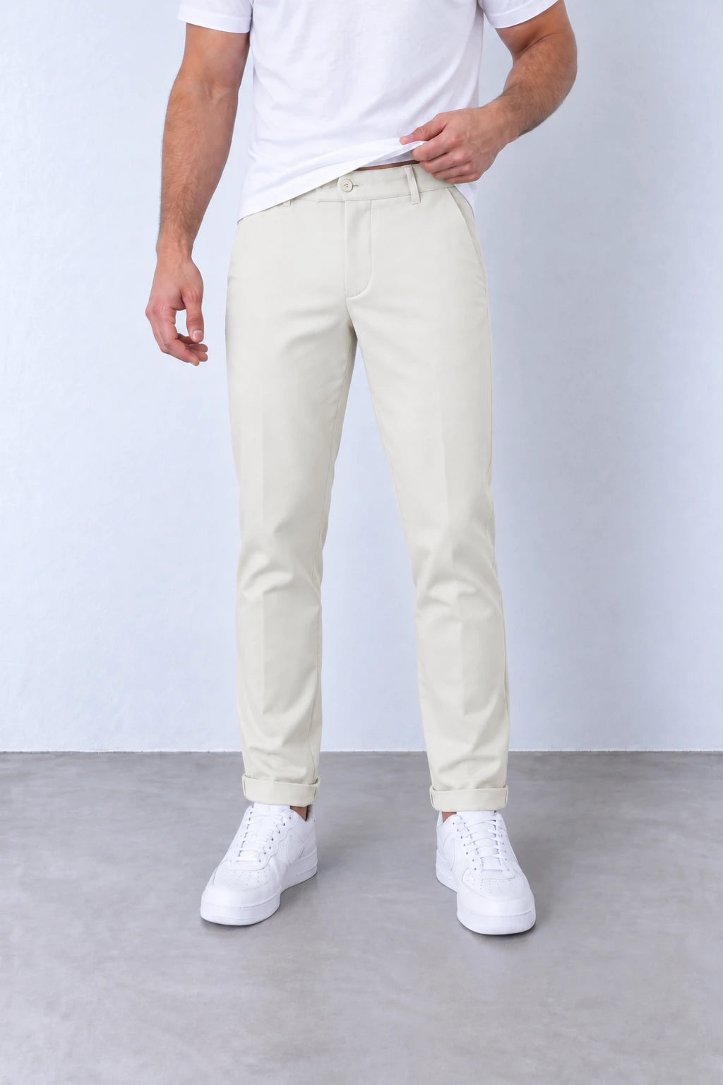 Pantaloni slim crem pentru bărbați, vedere frontală apropiată cu nasture, găici pentru curea și tiv cu rever.