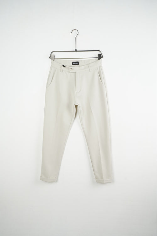 Pantaloni crem slim fit pentru bărbați, cu nasture, găici pentru curea și tiv cu rever, vedere frontală pe umeraș