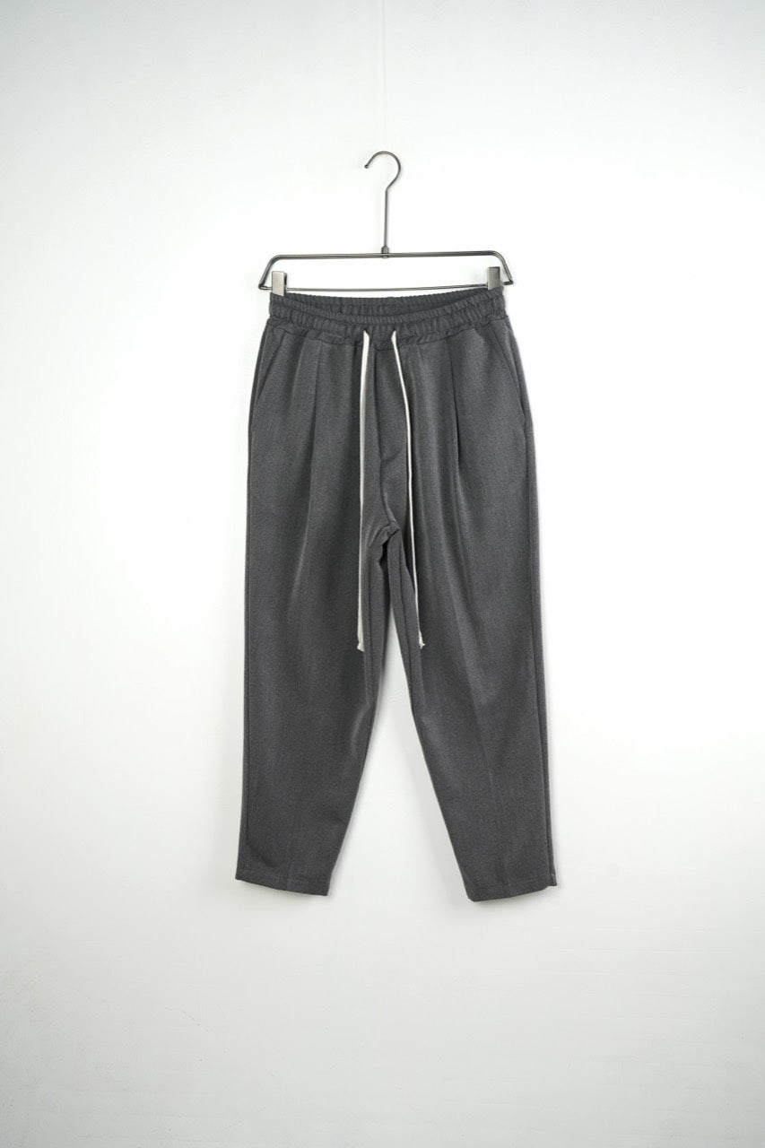 Pantaloni gri carrot fit pentru bărbați, cu talie elastică și șnururi albe, vedere frontală integrală pe umeraș
